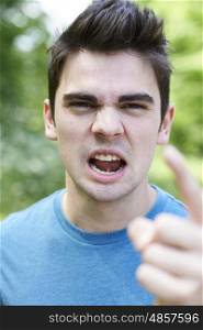Outdoor Head And Shoulders Portrait Of Angry Young Man