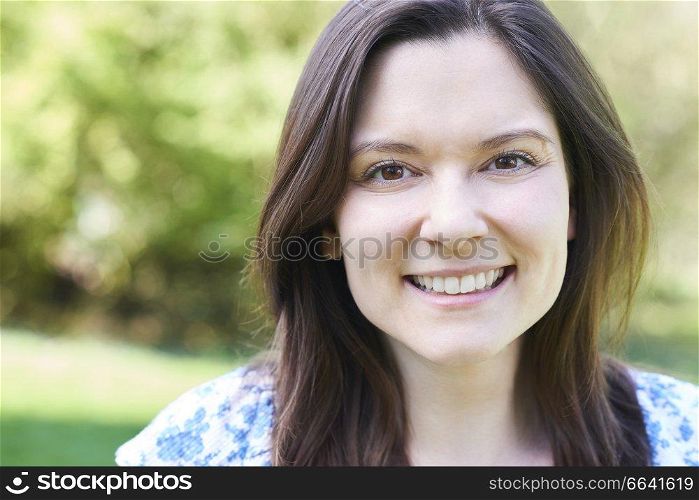 Outdoor Head And Shoulders Portrait Of Laughing Young Woman