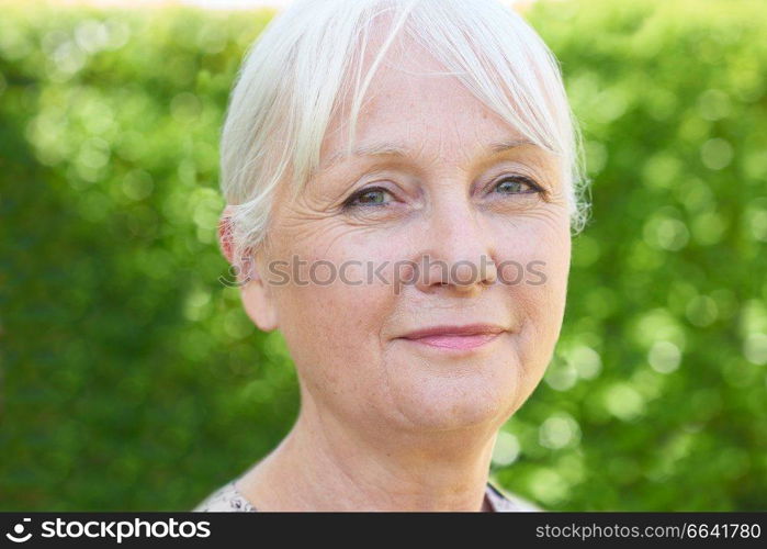 Outdoor Head And Shoulders Portrait Of Serious Senior Woman