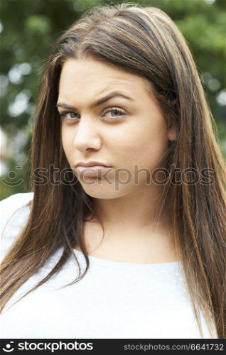 Outdoor Head And Shoulders Portrait Of Serious Teenage Girl