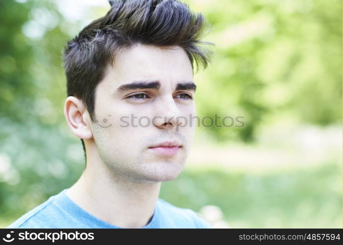 Outdoor Head And Shoulders Portrait Of Serious Young Man