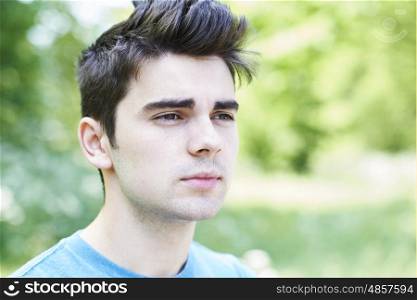 Outdoor Head And Shoulders Portrait Of Serious Young Man