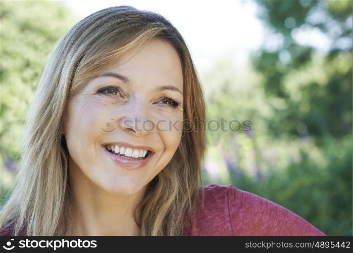 Outdoor Head And Shoulders Portrait Of Smiling Mature Woman