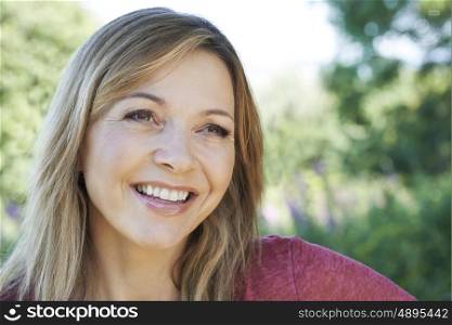 Outdoor Head And Shoulders Portrait Of Smiling Mature Woman