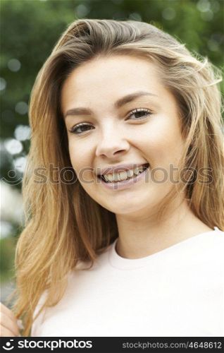 Outdoor Head And Shoulders Portrait Of Smiling Teenage Girl
