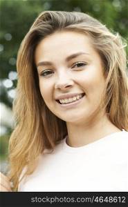 Outdoor Head And Shoulders Portrait Of Smiling Teenage Girl