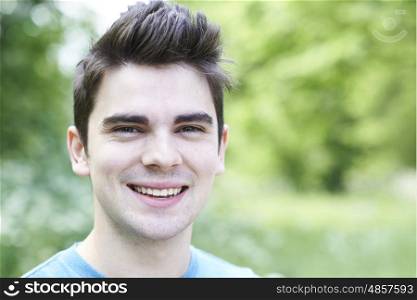 Outdoor Head And Shoulders Portrait Of Smiling Young Man