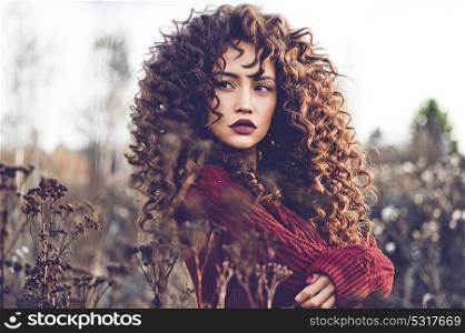 Outdoor lifestyle fashion photo of young natural beautiful lady in autumn landscape with dry flowers. Knitted sweater, wine lipstick. Warm Autumn. Fall vibes