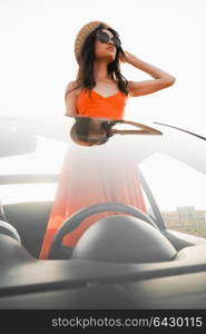 Outdoor lifestyle photo of beautiful happy woman in car cabriolet. Holiday and travel. Summer trip. Freedom, youth and carefree