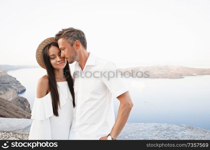 Outdoor lifestyle photo of happy young couple in white european town. Walking on Santorini island