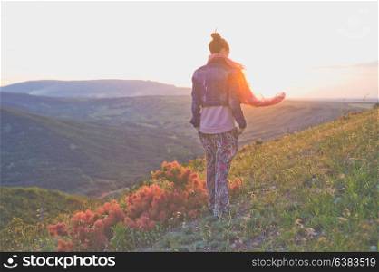 Outdoor lifestyle photo of young happy woman walking on mountain. Travel background. Tourism