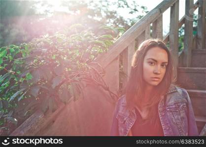 Outdoor lifestyle photo of young woman on wooden staircase. Travel background. Tourism.