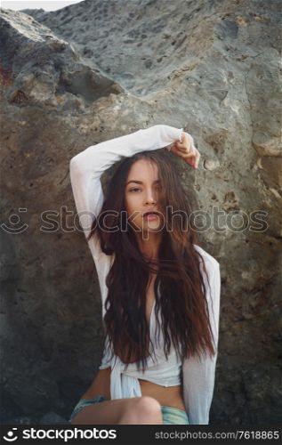 Outdoor lifestyle portrait of beautiful young brunette woman on the beach. Natural beauty. Travel and youth. Summer vibes