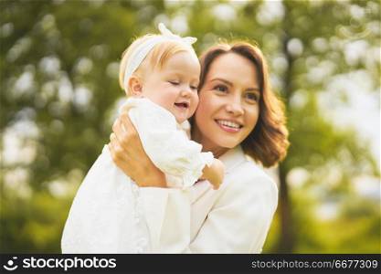 Outdoor lifestyle portrait of happy young beautiful mother and little cute daughter. Family, Love and Care. Summer image