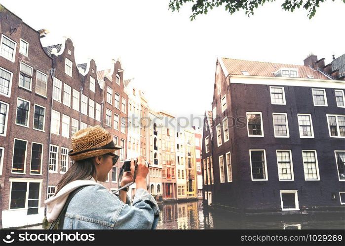 Outdoor lifestyle portrait of pretty young woman having fun in the city in Europe with digital camera travel photo of photographer Making pictures in hipster style