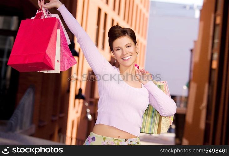 outdoor picture of happy woman with shopping bags