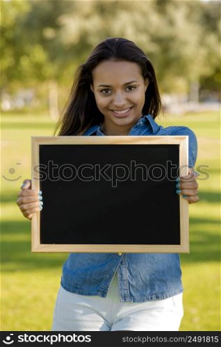 Outdoor portrait of a beautiful African American holding a shalkboard