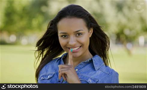 Outdoor portrait of a beautiful African American woman asking silence