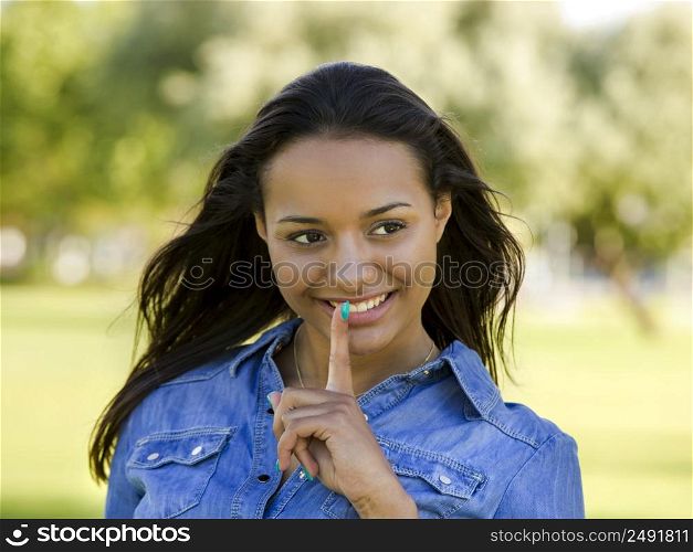 Outdoor portrait of a beautiful African American woman asking silence