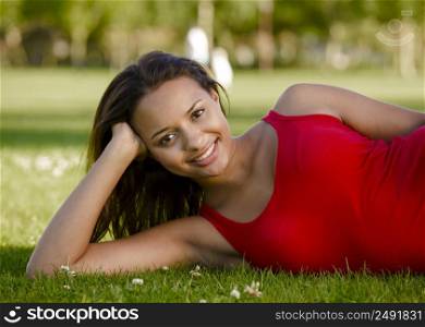 Outdoor portrait of a beautiful African American woman lying on the grass