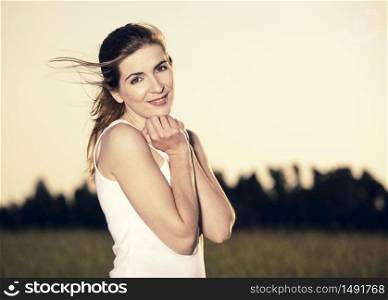 Outdoor portrait of a beautiful woman enjyoing the nature