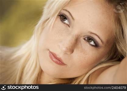 Outdoor portrait of a beautiful young woman thinking on something