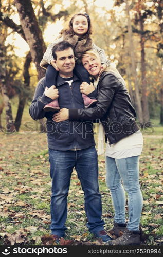 Outdoor portrait of a happy family enjoying the fall season