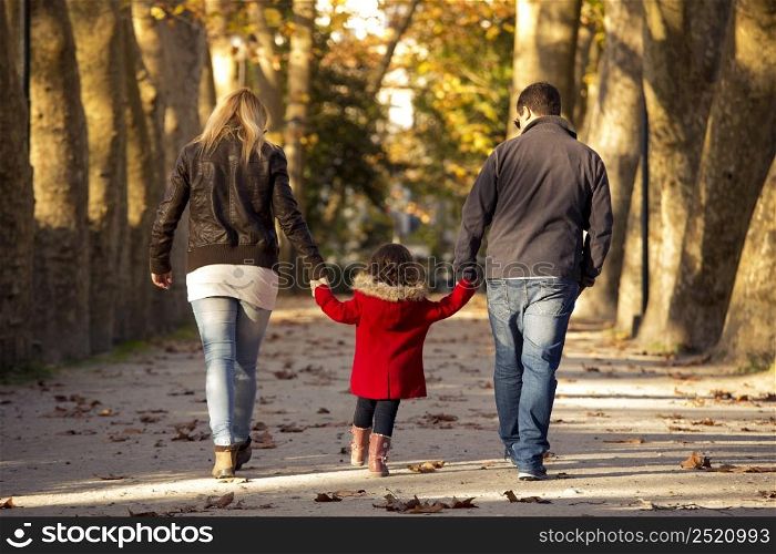 Outdoor portrait of a happy family walking together and enjoying the fall season