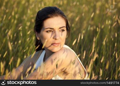 Outdoor portrait of a woman in a meadow on a summer day