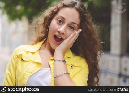 Outdoor portrait of a young beautiful latin woman with surprised facial expression