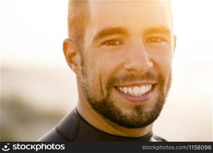 Outdoor portrait of an handsome young surfist smiling
