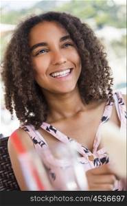 Outdoor portrait of beautiful happy mixed race African American girl teenager female child smiling with perfect teeth