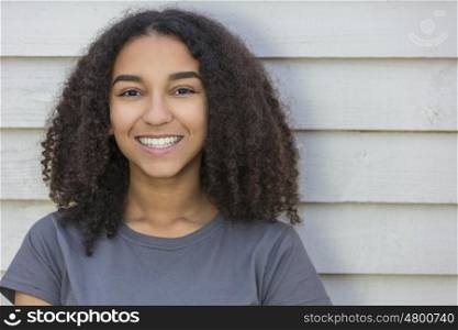 Outdoor portrait of beautiful happy mixed race African American girl teenager female child smiling with perfect teeth