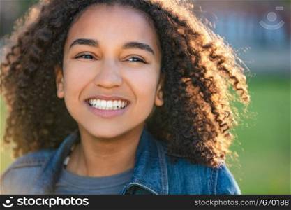 Outdoor portrait of beautiful happy mixed race African American girl teenager female young woman smiling with perfect teeth