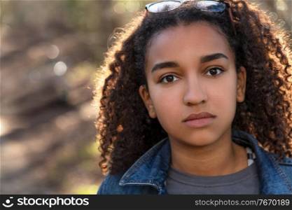 Outdoor portrait of beautiful happy mixed race African American girl teenager female child looking thoughtful or sad