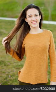 Outdoor portrait of beautiful happy teenager girl laughing while the wind moves her hair