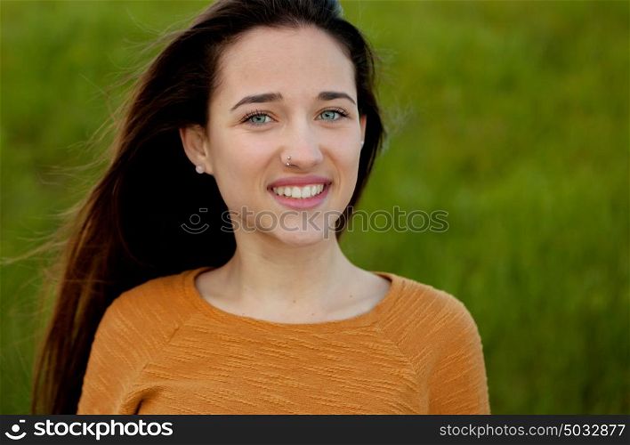 Outdoor portrait of beautiful happy teenager girl laughing with perfect teeth in field