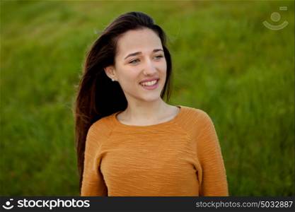 Outdoor portrait of beautiful happy teenager girl laughing with perfect teeth in field