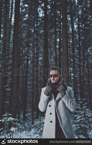 Outdoor portrait of handsome man in coat and scurf. Casual winter fashion