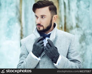 Outdoor portrait of handsome man in gray coat. Fashion photo. Beauty winter style