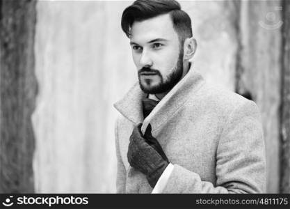 Outdoor portrait of handsome man in gray coat. Fashion photo. Beauty winter style. Black and White