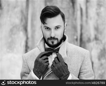 Outdoor portrait of handsome man in gray coat. Fashion photo. Beauty winter style. Black and White