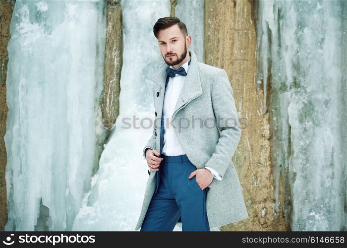 Outdoor portrait of handsome man in gray coat. Fashion photo. Beauty winter style