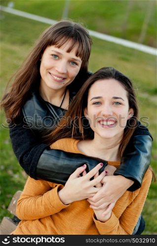 Outdoor portrait of two happy sisters relaxed in a park