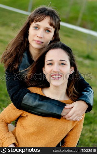 Outdoor portrait of two happy sisters relaxed in a park