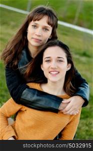 Outdoor portrait of two happy sisters relaxed in a park