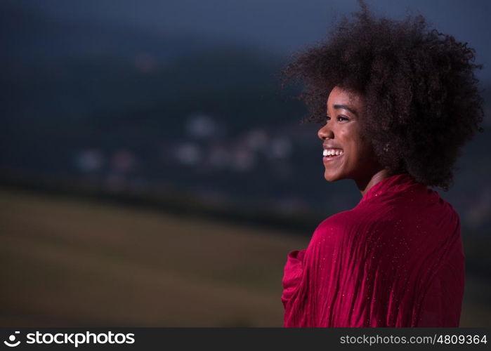 Outdoor portrait of young beautiful black woman with red scarf around shoulder