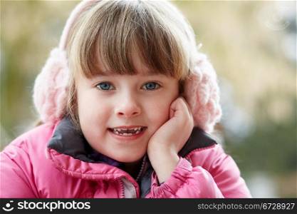 Outdoor Portrait Of Young Girl Wearing Winter Clothes And Earmuffs