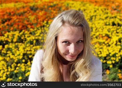 Outdoor portrait of young woman against flowerbed