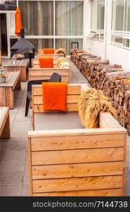 Outdoor restaurant terrace with wooden furniture in scandinavian style. Eco-friendly authentic design.